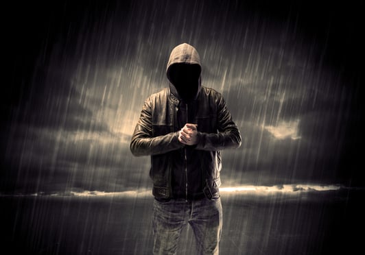 A faceless thief in unrecognizable hoodie standing in the middle of the night in the rain in front of landscape concept