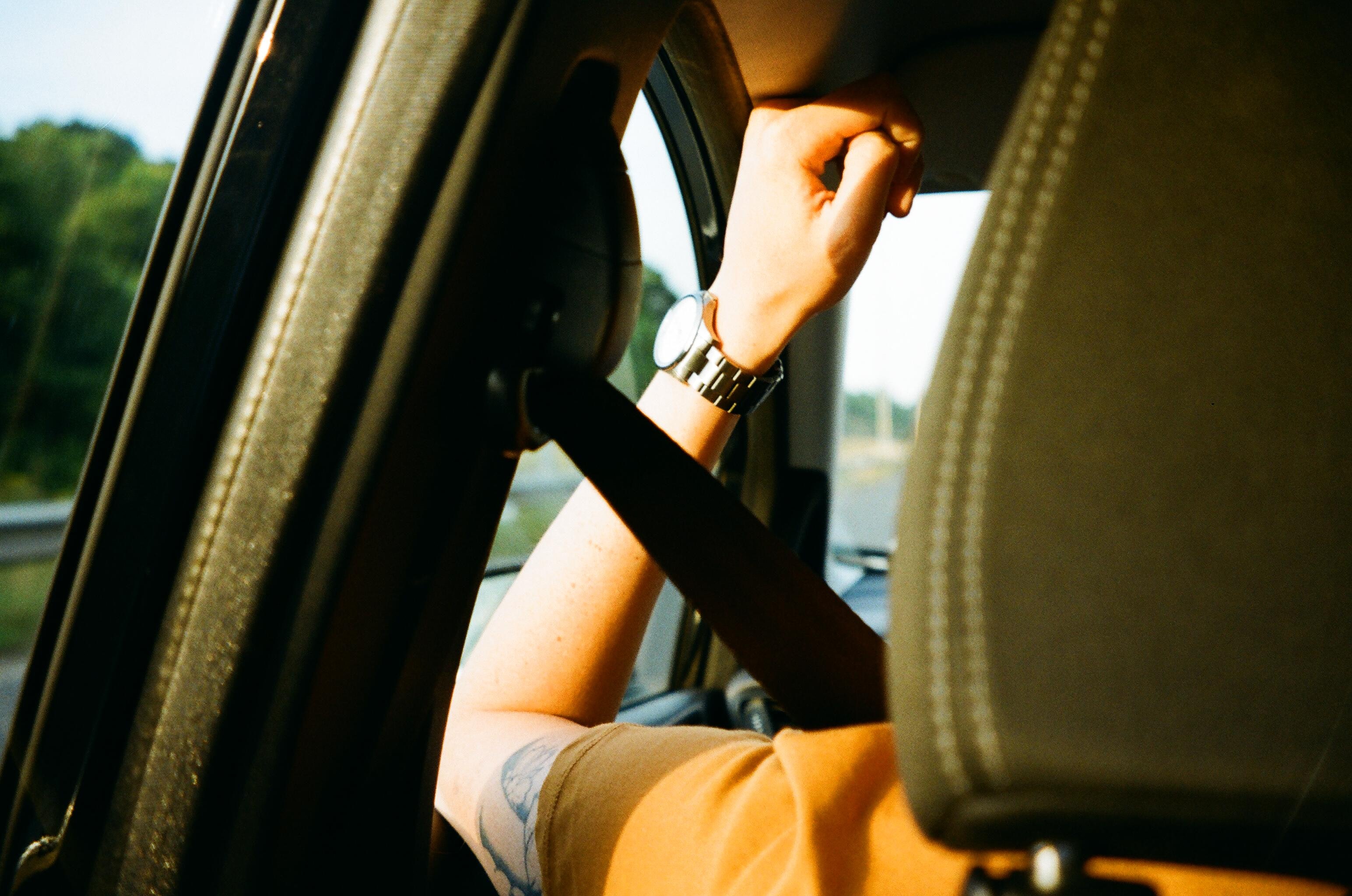 Passenger sitting in car with seatbelt on.